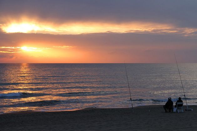 San Vincenzo, Angler zum Sonnenuntergang am Strand des Thyrrenischen Meeres