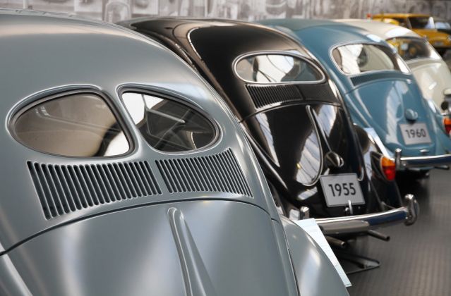Eine Volkswagen Käfer-Heckparade, angeführt vom Brezel- und vom folgenden Ovali-Käfer - AutoMuseum Volkswagen, Wolfsburg