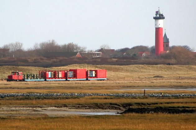 Eine Schöma Diesellok der Baureihe 399 mit einem Gepäckzug vor dem alten Leuchtturm Wangerooges
