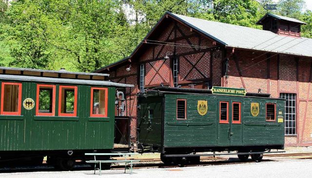 Das Sächsische Schmalspurbahn-Museum Rittersgrün - ein historischer Personenwagen und der Kaiserliche Postwagen vor dem Lokschuppen