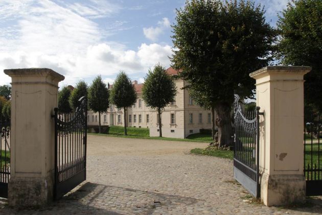 Rheinsberg in Brandenburg - die Pforte zum Schloss mit der Schlossfassade zum Marktplatz