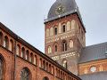 Lettlands Hauptstadt Riga - der Turm des Rigaer Doms mit einem Teil des Kreuzganges des Domkapitelklosters