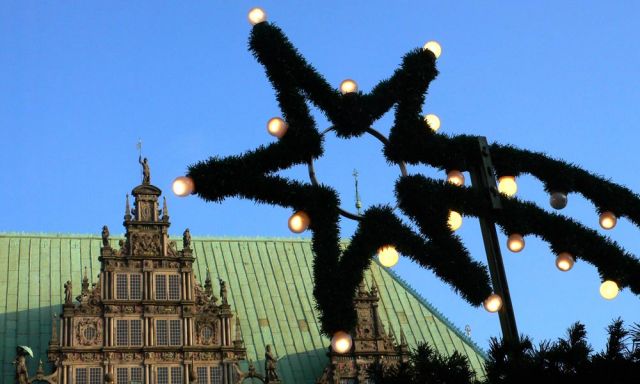 Der Bremer Weihnachtsmarkt auf dem historischen Marktplatz - ein Weihnachtsstern vor der Rathaus-Fassade